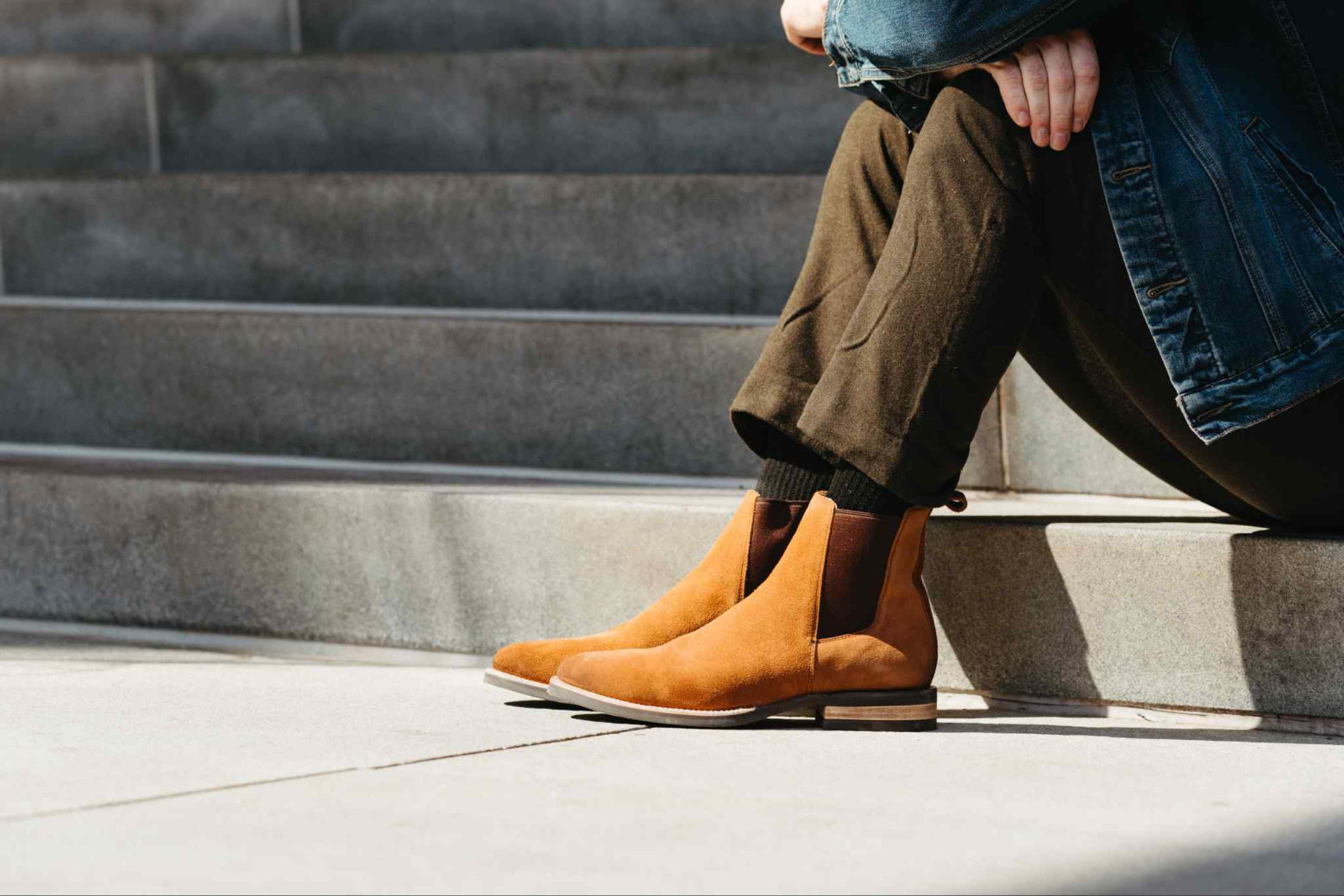 Person wearing brown leather boots sitting on steps