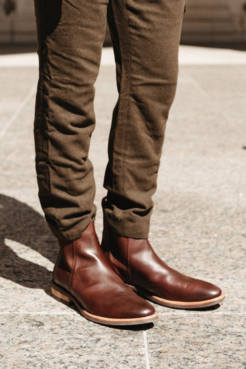 Brown leather boots and pants on a concrete surface