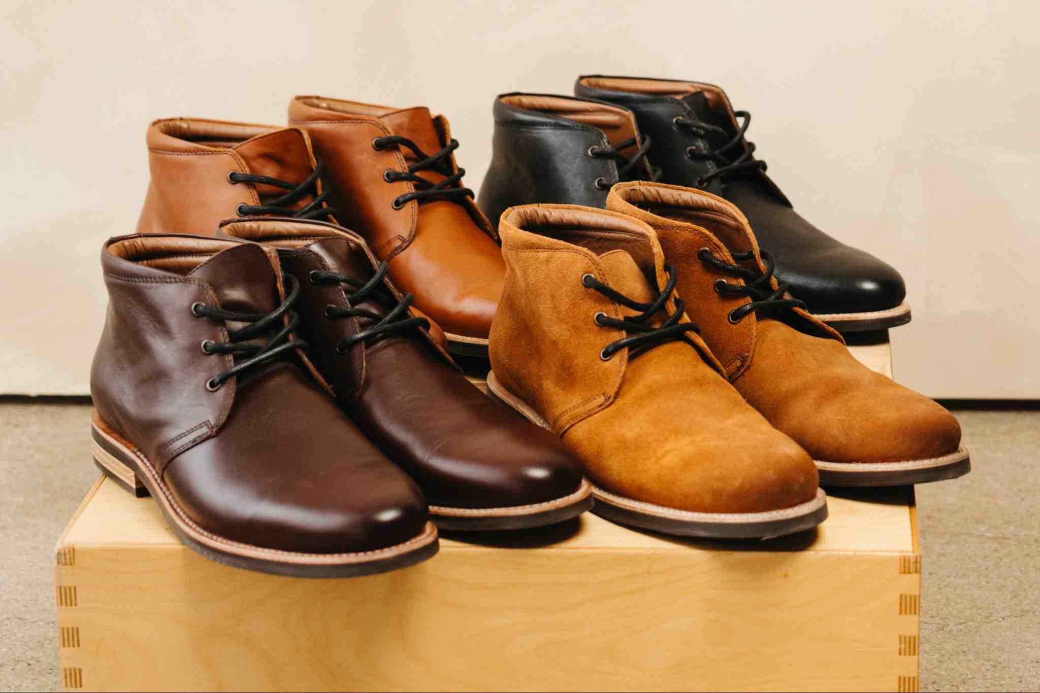 Group of Andres Commuter Chukka Boots in multiple leather colors on a wooden block — Andres Handcrafted Boots